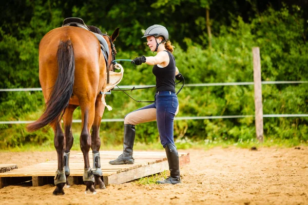 Jockey ung kvinna sig hästen redo för ride — Stockfoto