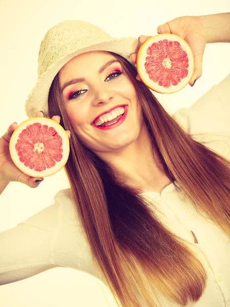 Mulher segura duas metades de frutas cítricas de toranja nas mãos — Fotografia de Stock
