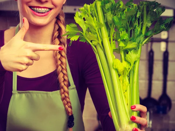 Kadın mutfakta yeşil kereviz tutar — Stok fotoğraf