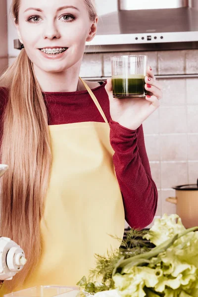 Woman in kitchen holding vegetable juice — Stock Photo, Image