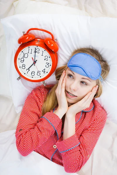 Shocked woman wearing pajamas holding clock overslept — Stock Photo, Image