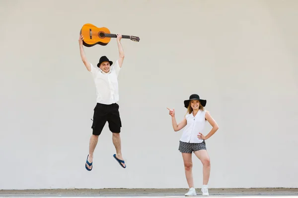 Man woman wijzend op hem met gitaar, springen — Stockfoto