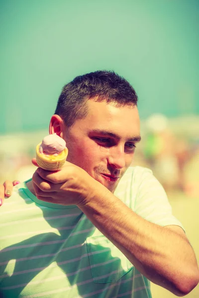 Glücklicher Mann isst Eis am Strand — Stockfoto