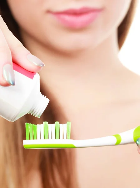 Femme appliquant du dentifrice sur sa brosse à dents — Photo