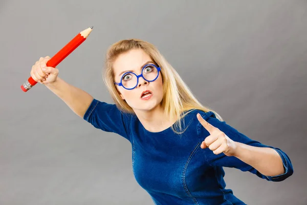 Mujer enojada sostiene lápiz grande en la mano — Foto de Stock