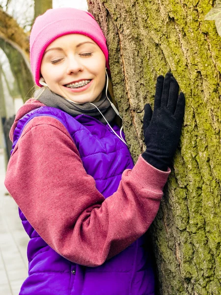 Woman wearing sportswear hugging tree — Stock Photo, Image