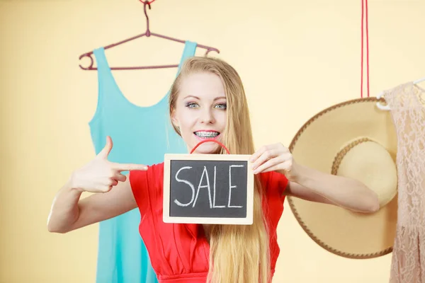 Žena v obchodě vybírání oblečení, prodej koncepce — Stock fotografie