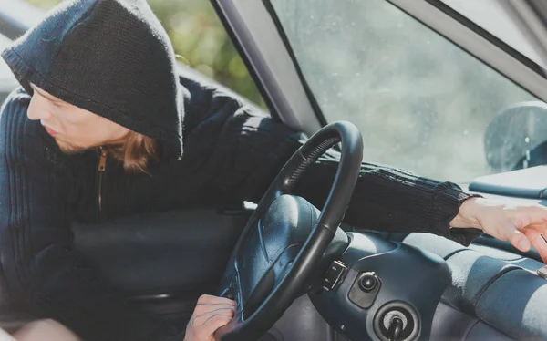 Ladrão assaltante invadindo carro e roubando — Fotografia de Stock