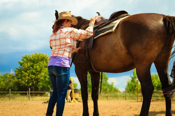 Cowgirl, przygotowania konia do jazdy na wsi — Zdjęcie stockowe