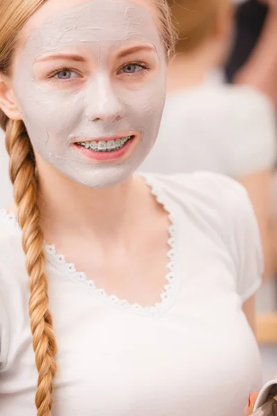 Feliz joven mujer teniendo máscara de barro en la cara — Foto de Stock