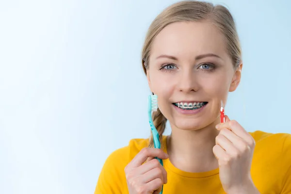 Mulher sorrindo dentes de limpeza com aparelho — Fotografia de Stock