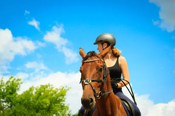 Jockey girl gör häst ridning på landsbygden äng — Stockfoto