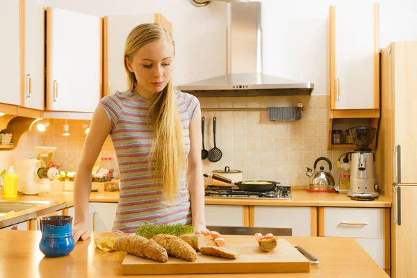 Woman in kitchen holding knife making healthy sandwich — Stock Photo, Image