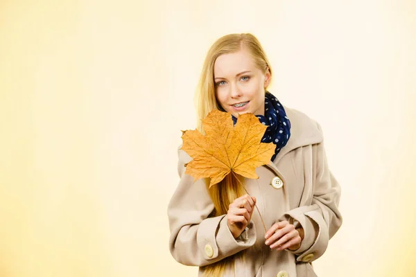 Frau mit orangefarbenem Herbstblatt — Stockfoto