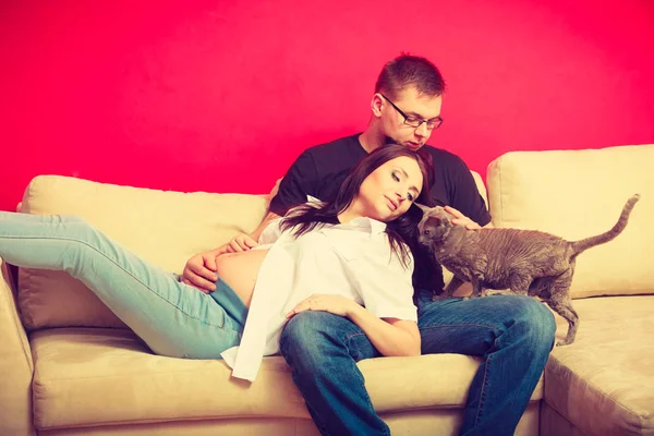 Donna incinta e uomo rilassante sul divano — Foto Stock