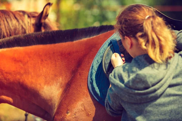 Fantino giovane donna ottenere cavallo pronto per la corsa — Foto Stock