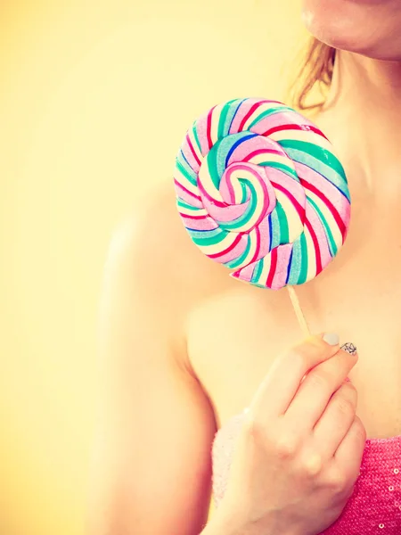 Woman holds colorful lollipop candy in hand — Stock Photo, Image