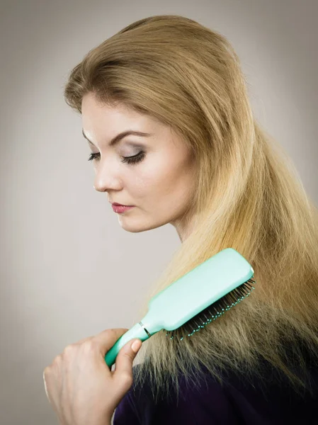 Mulher escovando seu cabelo longo com escova — Fotografia de Stock