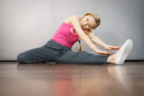 Woman in sportswear stretching legs — Stock Photo, Image