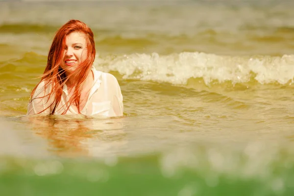 赤毛の女性の夏の中で水で遊ぶ — ストック写真