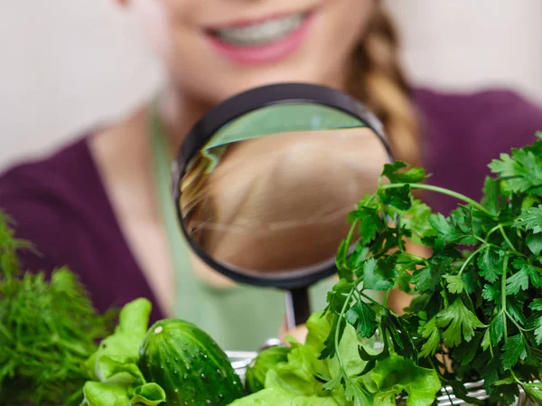 Mujer mirando lupa a las verduras —  Fotos de Stock