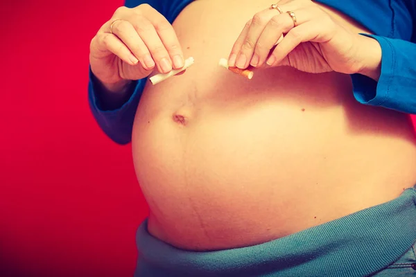 Těhotná žena s velkou žaludek prolomit cigaret — Stock fotografie