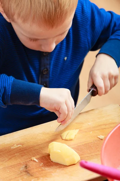 Jongetje peeling appels met mes en eten — Stockfoto