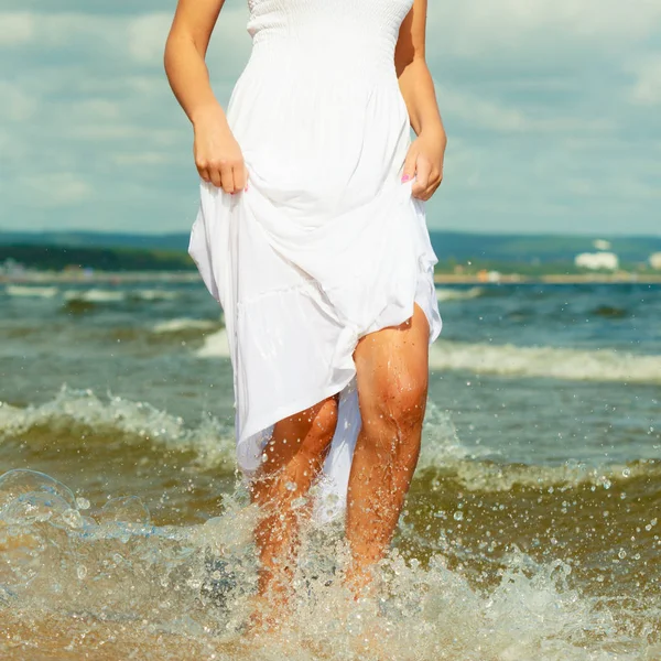 Mulher loira vestindo vestido andando na água — Fotografia de Stock