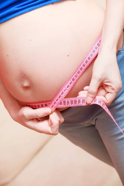 Mujer embarazada midiendo su vientre de cerca — Foto de Stock
