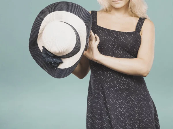 Mujer vistiendo vestido corto azul marino sosteniendo sombrero de sol —  Fotos de Stock