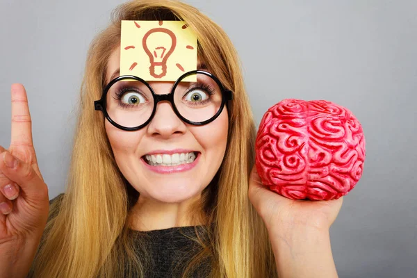 Mujer extraña sosteniendo el cerebro teniendo idea — Foto de Stock