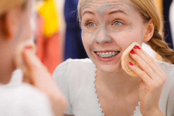 Donna rimozione maschera viso fango con spugna — Foto Stock