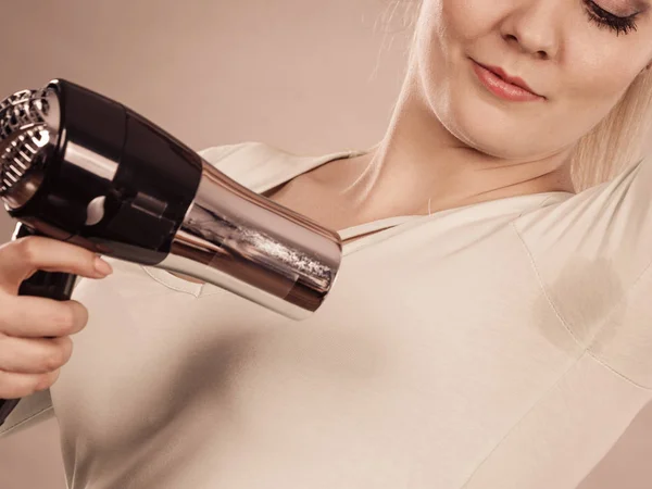 Woman drying armpit with hair dryer — Stock Photo, Image