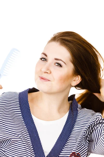 Mulher escovando seu cabelo longo usando pente — Fotografia de Stock