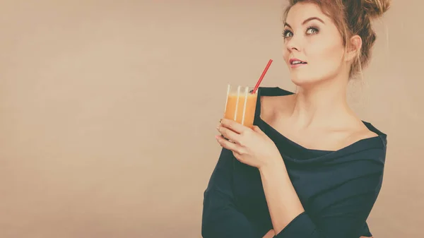 Femme pensante tenant du jus d'orange frais — Photo