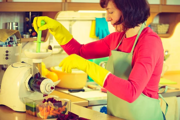 Woman make vegetables juice in juicer machine — Stock Photo, Image