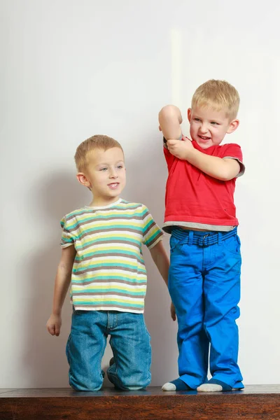 Two little boys siblings playing together on table — Stock Photo, Image