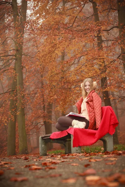 Blondes Mädchen liest Buch in herbstlicher Landschaft — Stockfoto