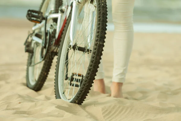 Unrecognizable woman bike cycling on sand — Stock Photo, Image