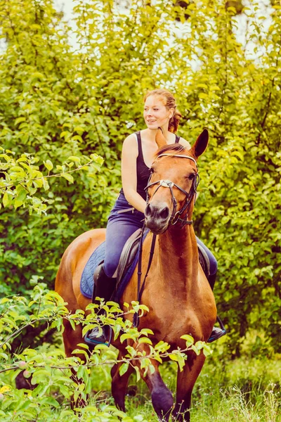 Jeune femme chevauchant un cheval — Photo