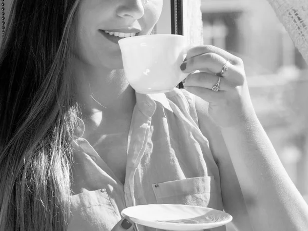 Femme regardant par la fenêtre, relaxant boire du café — Photo