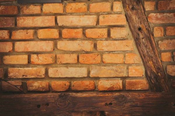 Red brick wall with wooden pieces — Stock Photo, Image