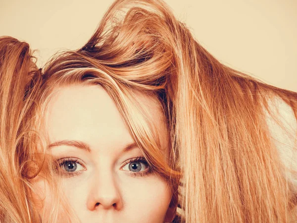 Kobieta blonde trzymając długo splątane włosy — Zdjęcie stockowe