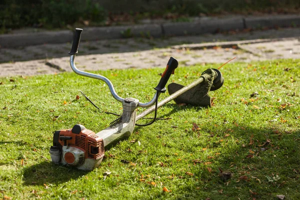 Biçme makinesi brushcutter yeşil çimenlerin üzerinde — Stok fotoğraf