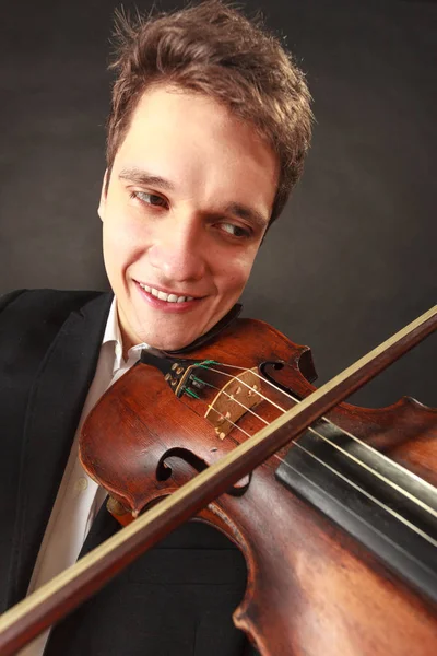 Mies soittaa viulua, jossa näkyy tunteita ja ilmaisuja — kuvapankkivalokuva