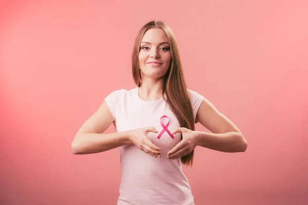 Brustkrebs. Frau macht Herzform auf rosa Schleife — Stockfoto