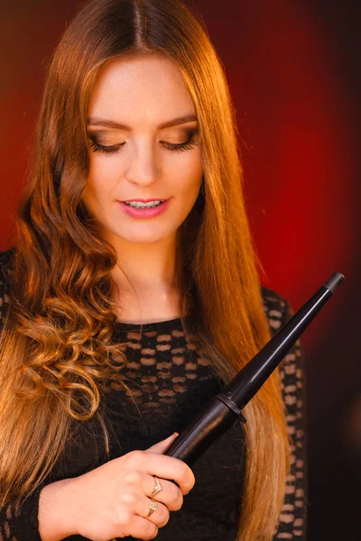 Happy woman curling her long brown hair — Stock Photo, Image