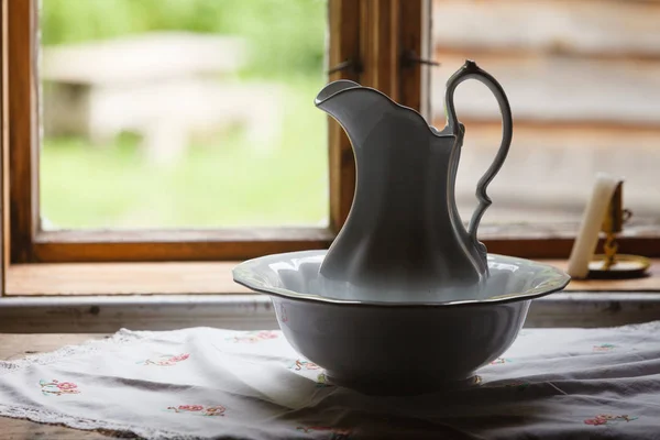 Old vintage window, ceramic jug in foreground — Stock Photo, Image