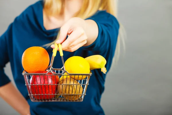 Kvinna som håller varukorg med frukter inuti — Stockfoto