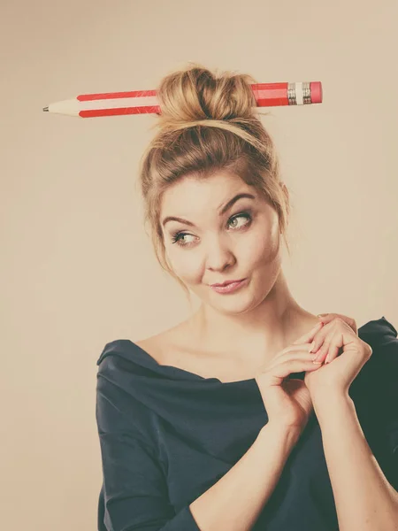 Happy blonde woman having big pencil in hair — Stock Photo, Image